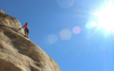 Climber about to reach a mountain top