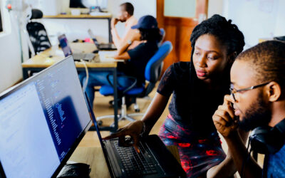 Student and teacher look at a computer screen