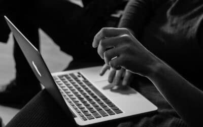 Hands resting at a laptop keyboard