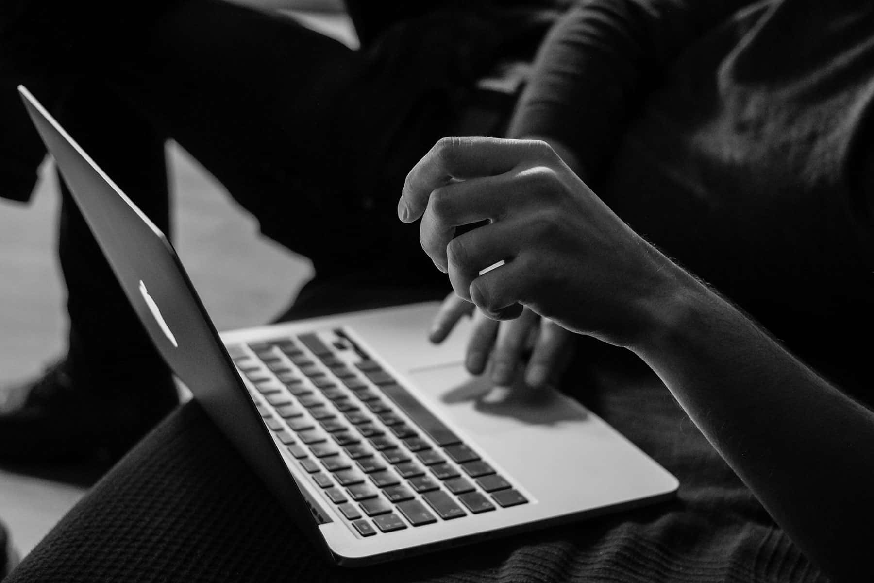 Hands resting at a laptop keyboard